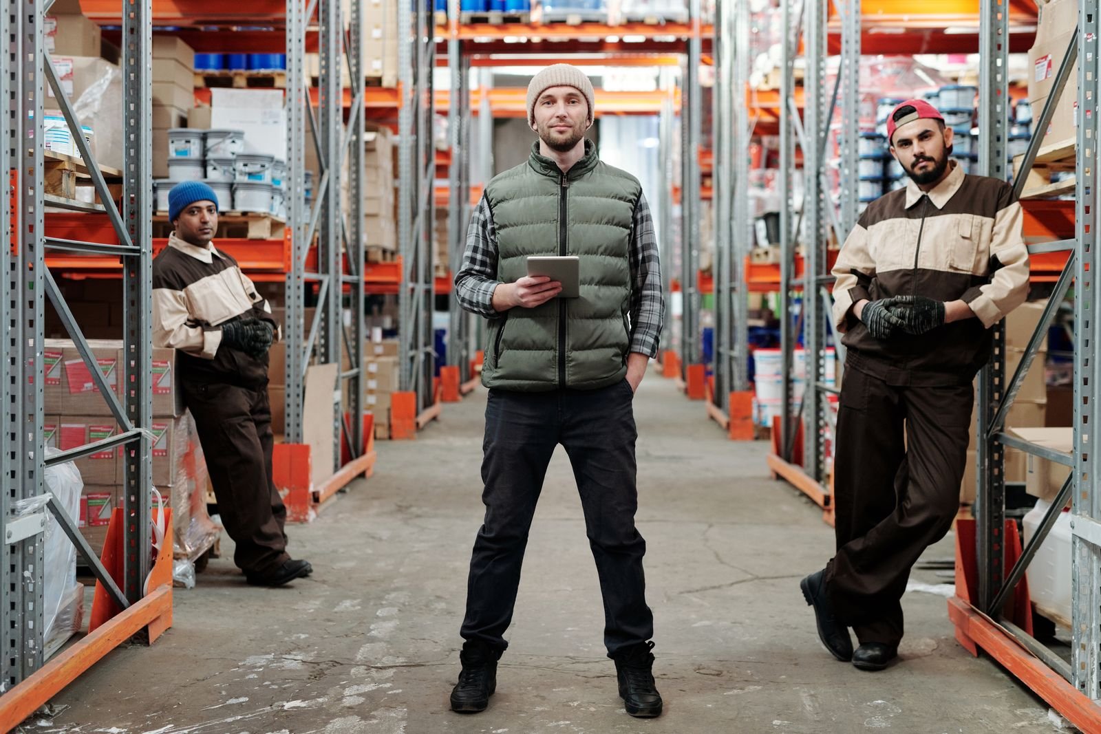 Warehouse team standing in an aisle between shelves